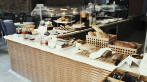 A buffet counter with various food items and utensils. - Astron Hotel (Ierapetra)