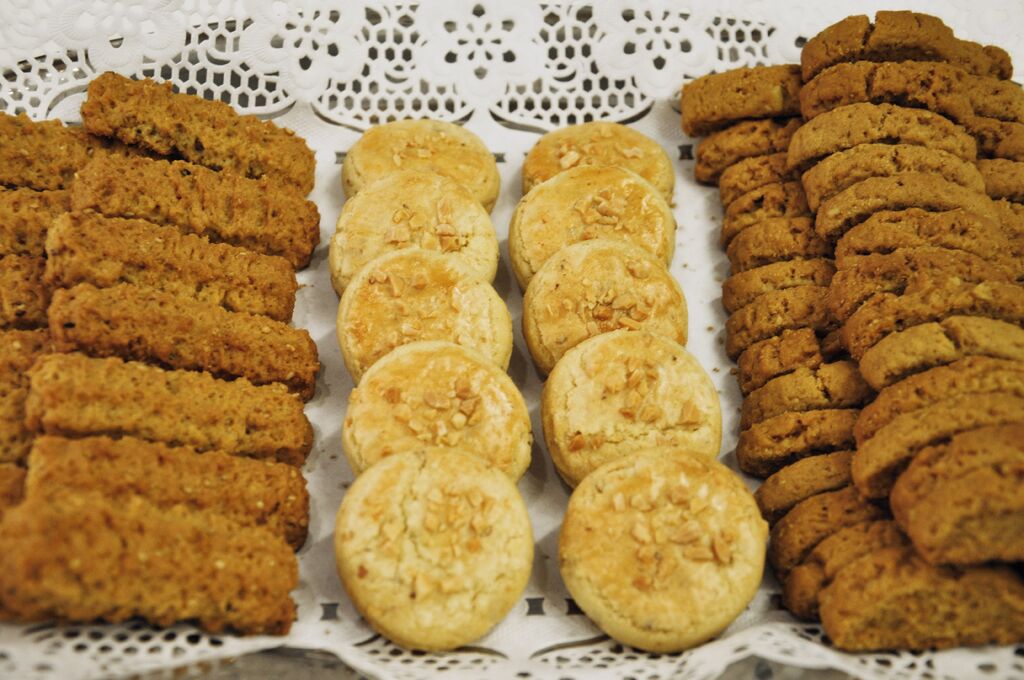 A variety of cookies arranged on a lace tablecloth.