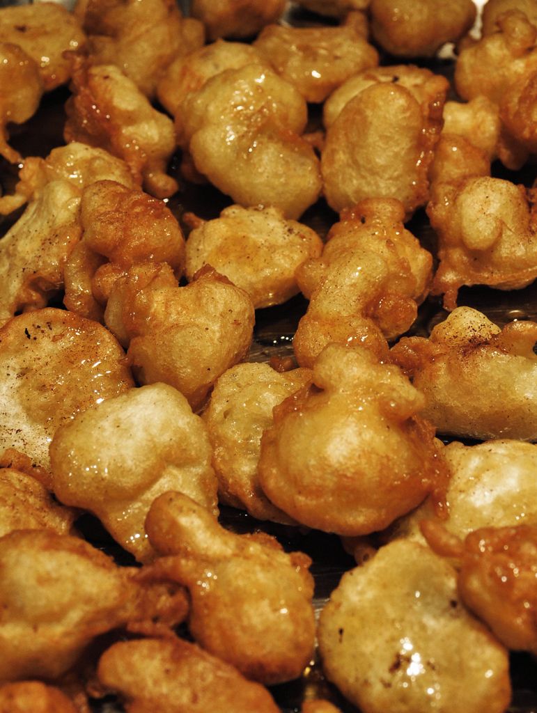 A close-up of fried dough balls, likely fritters, with a golden-brown crust.