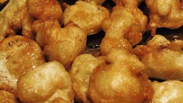 A close-up of fried dough balls, likely fritters, with a golden-brown crust.