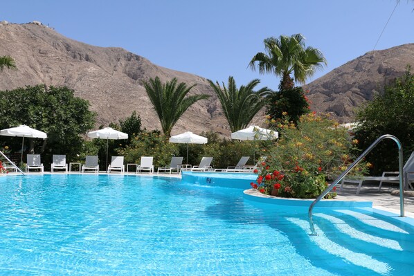 Piscine extérieure en saison, parasols, chaises longues