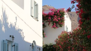 A white building with blue shutters, a staircase, and pink bougainvillea flowers. - Spiros & Hiroko Hotel - Adults Only (Santorini)