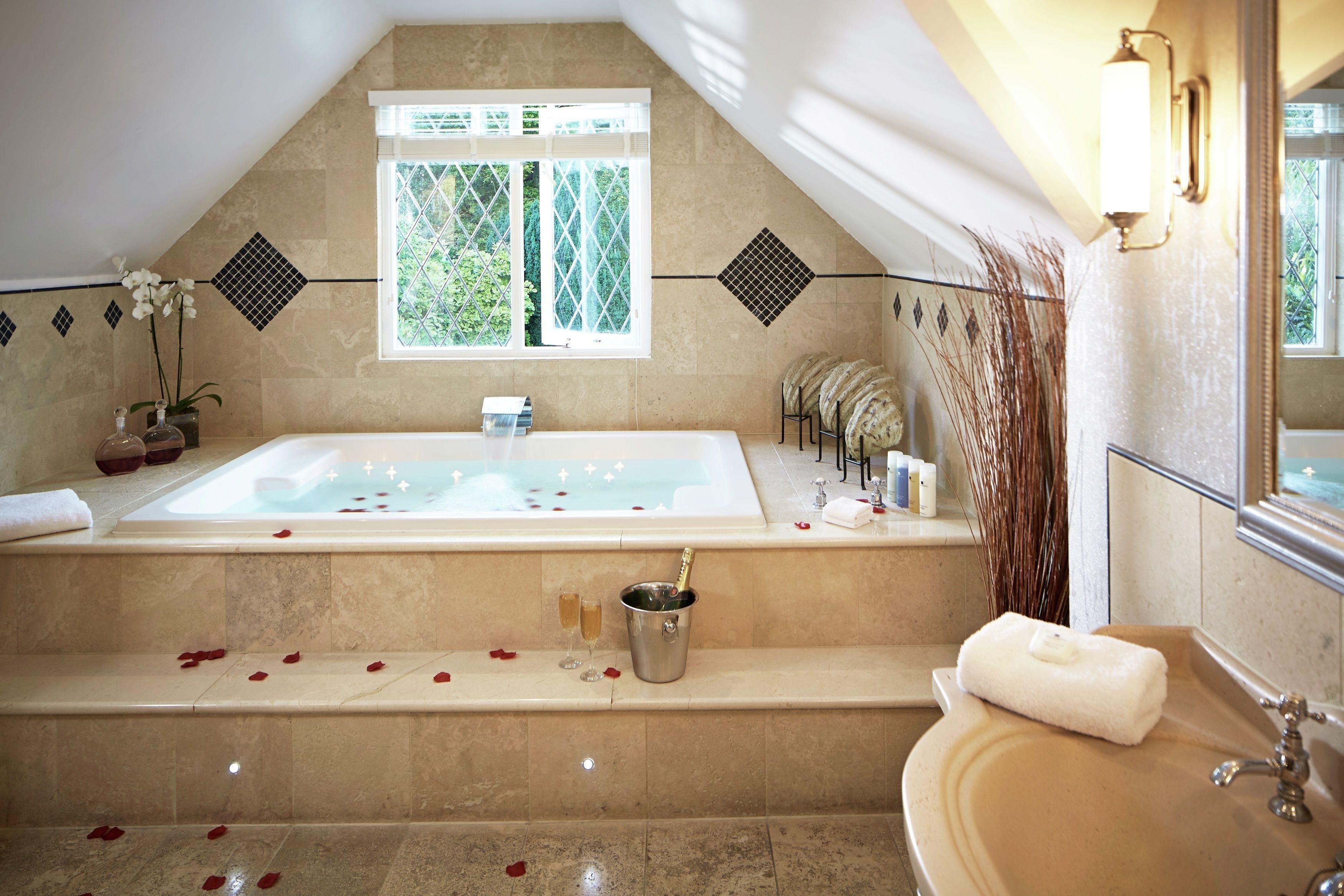 Un baño con una bañera grande, un lavabo y una ventana.
