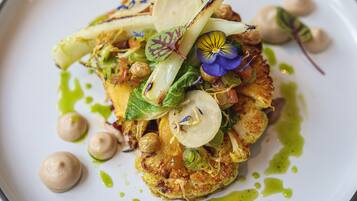 A plated dish with various vegetables and garnishes.