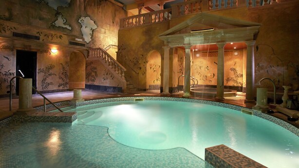 An indoor swimming pool with a tiled floor, a staircase with a balustrade, and a wall with a mural. - Rowhill Grange Hotel & Utopia Spa (Dartford)