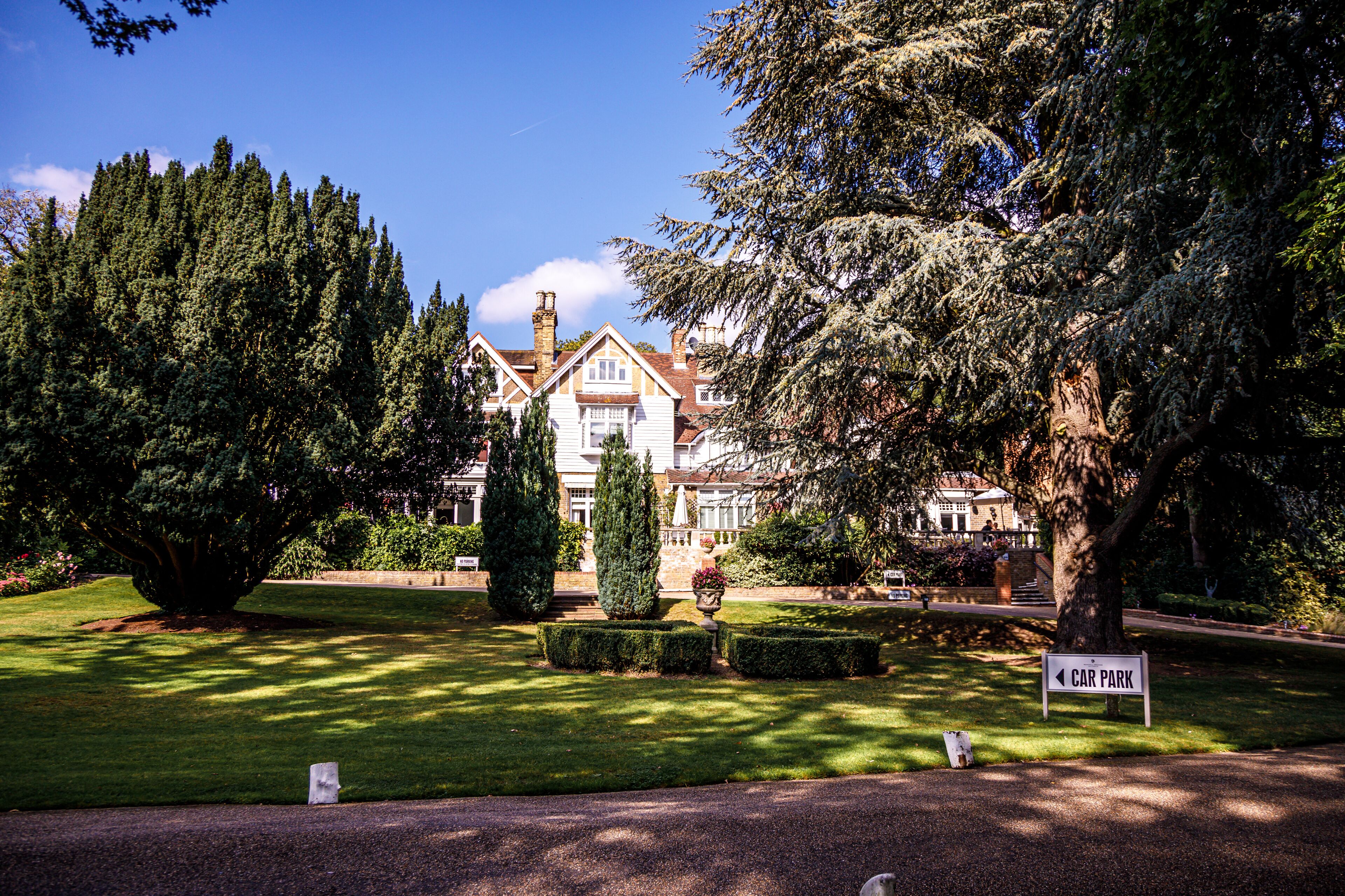 A well-maintained garden with a sign indicating a car park.