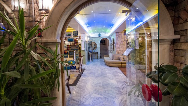 An interior with a marble floor, a seating area, and a glass wall with a view of the street. - Krikonis Hotel (Ioannina)