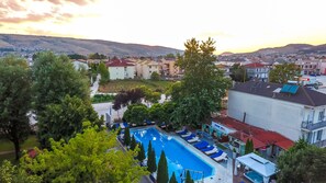 Relax by the pool surrounded by lush greenery and mature trees in a tranquil suburban setting.