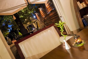 Enjoy al fresco dining in a serene outdoor setting with a table, chairs, and lush surroundings.