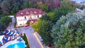 A hotel with a pool, outdoor seating, and a well-maintained garden. - Krikonis Hotel (Ioannina)