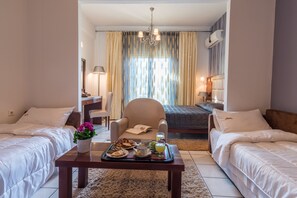 Habitación cuádruple | Área de sala de estar | Televisión 