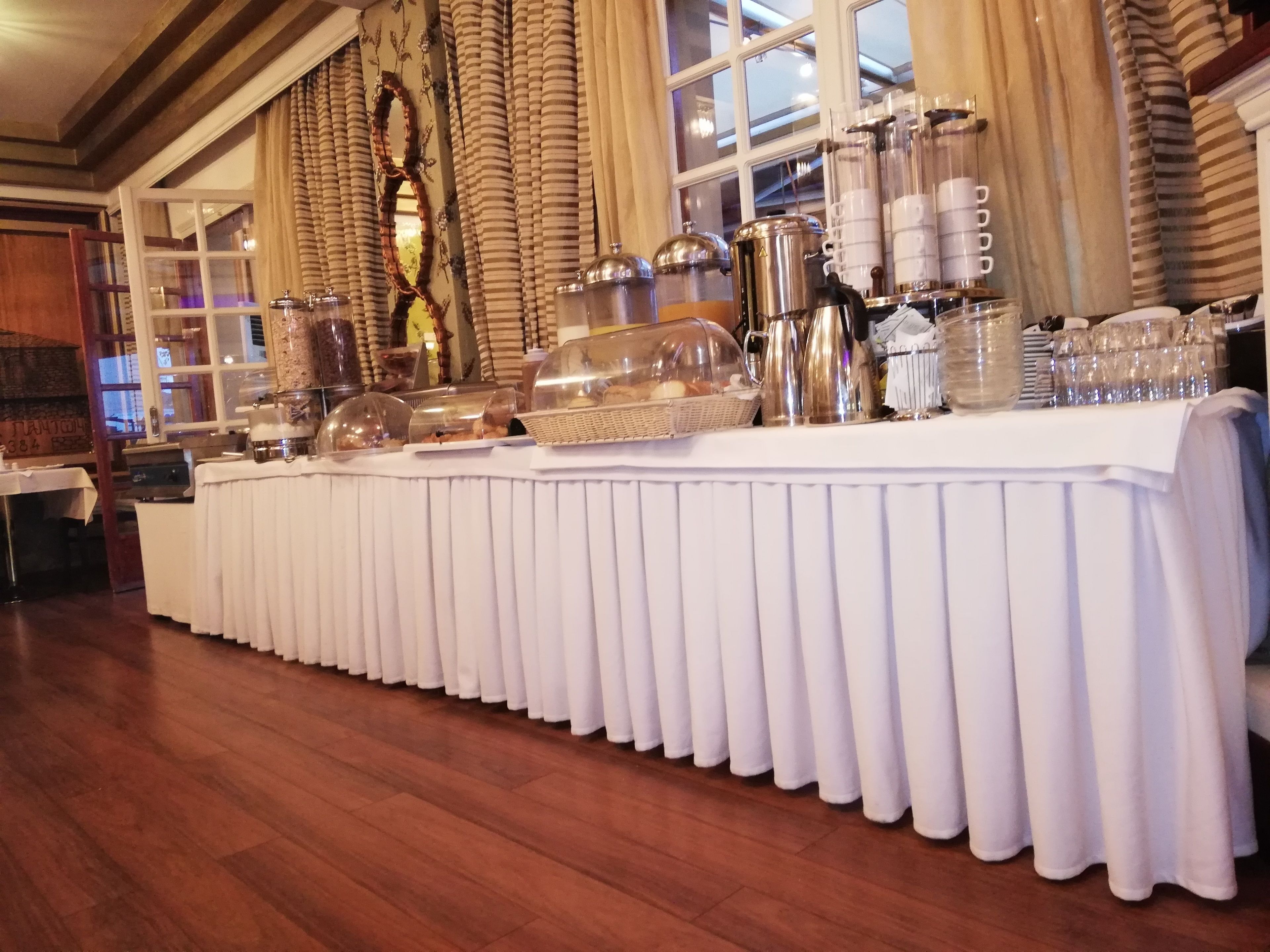 A buffet setup with various food containers and serving equipment.