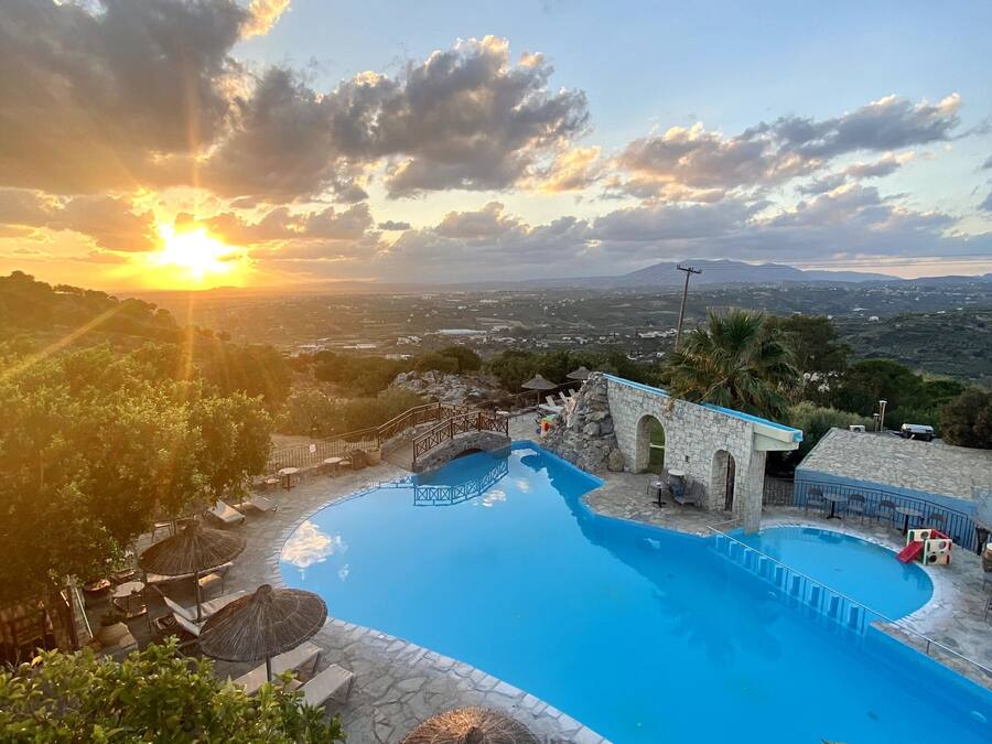 Una piscina al aire libre, sombrillas, sillones reclinables de piscina