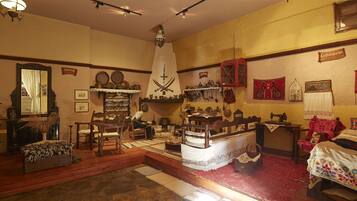 A room with a bed, a chair, a table, and various decorative items.