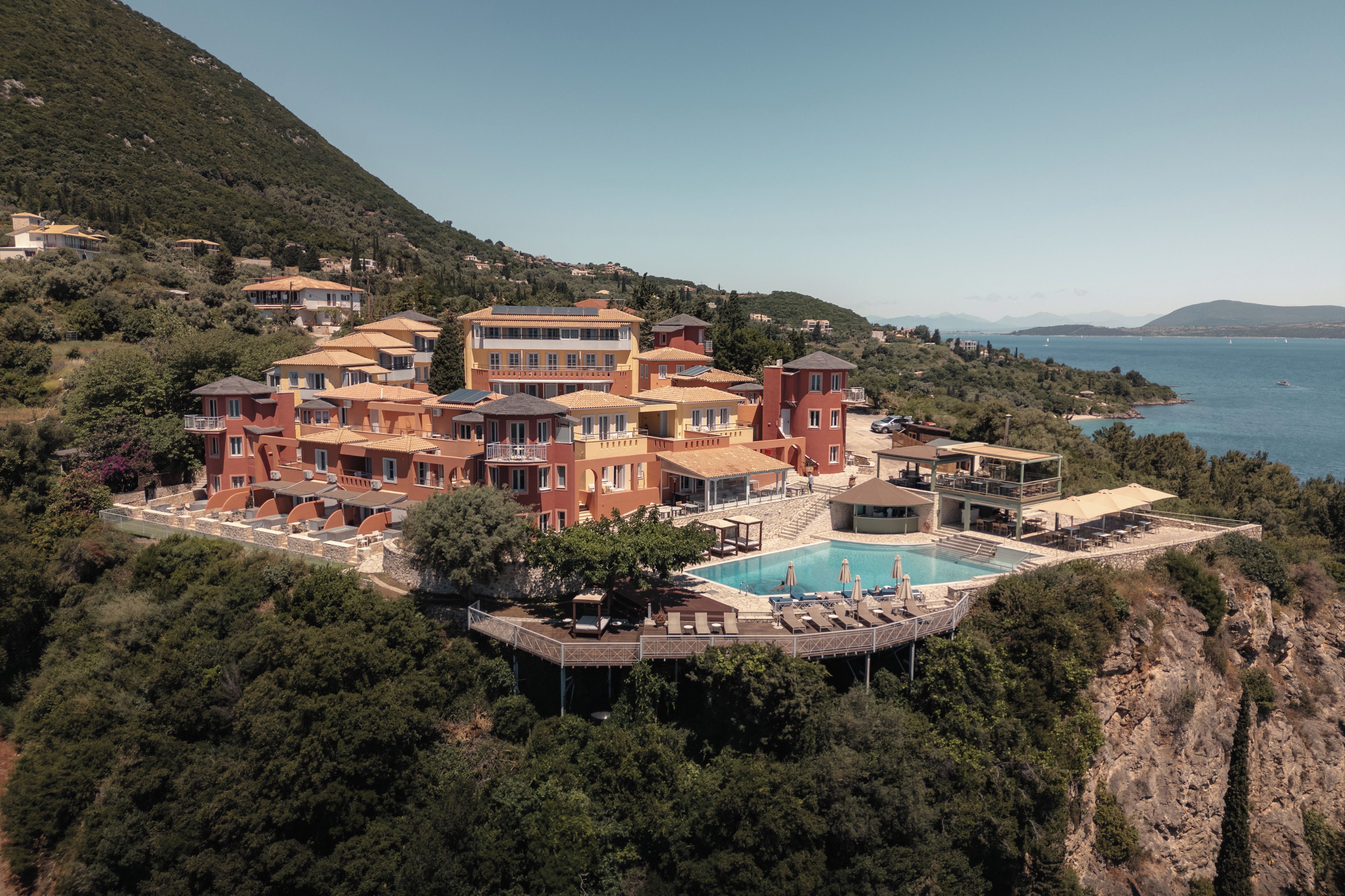 Ein Küstenresort mit mehreren Gebäuden, einem Schwimmbad und Meerblick.