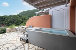 A stone patio with a pool, outdoor seating, and a view of a green hillside. - Red Tower (Lefkada)