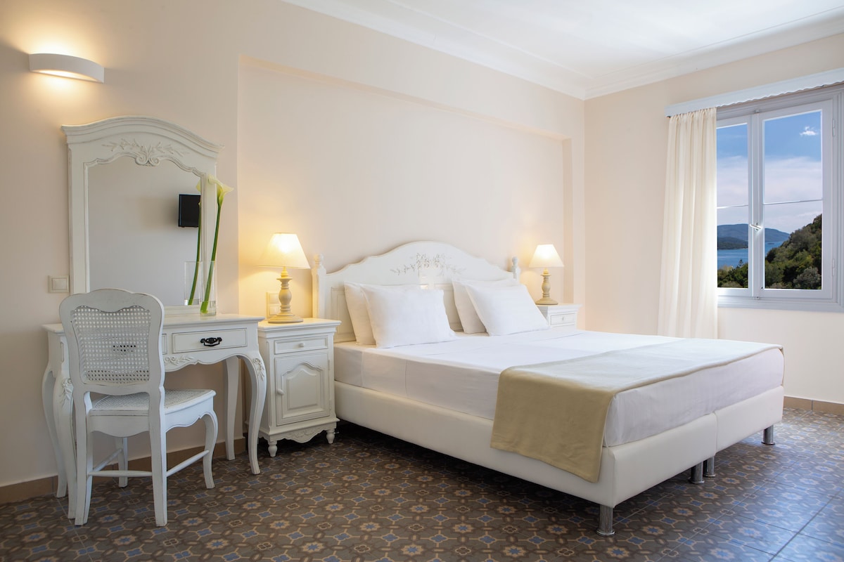 Un dormitorio con una cama grande, un escritorio, una silla y un espejo.
