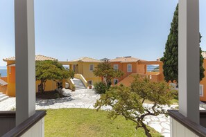 Un patio con un camino de piedra que conduce a un edificio de paredes anaranjadas y techo de tejas.