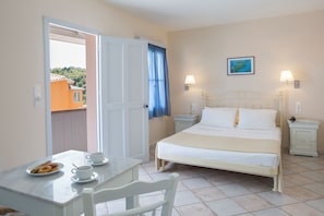 Hotelkamer met een bed, nachtkastjes, een tafel met koekjes en uitzicht.