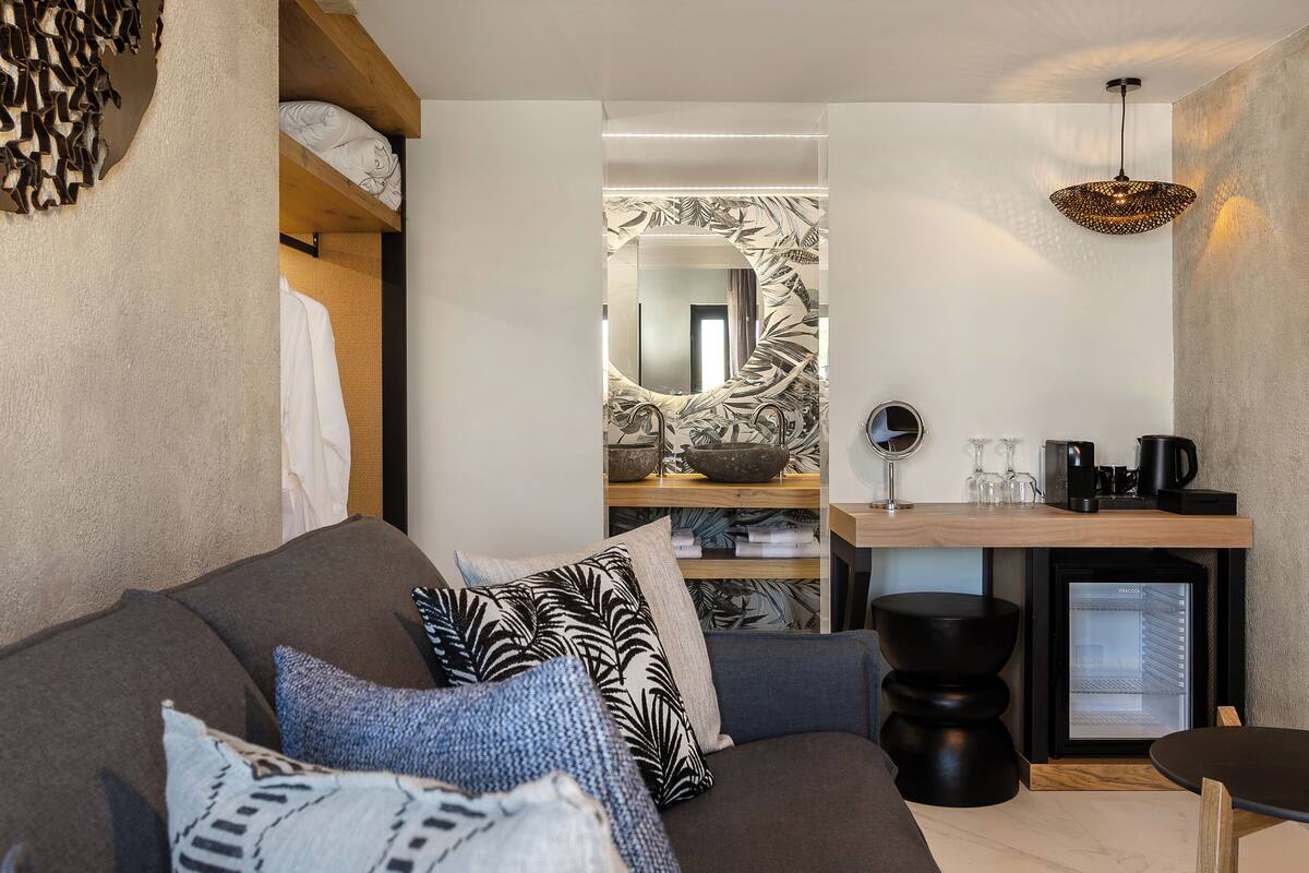 A modern interior with a sofa, a dining area, and a kitchen.