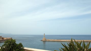 A terrace with potted plants and a view of the sea.