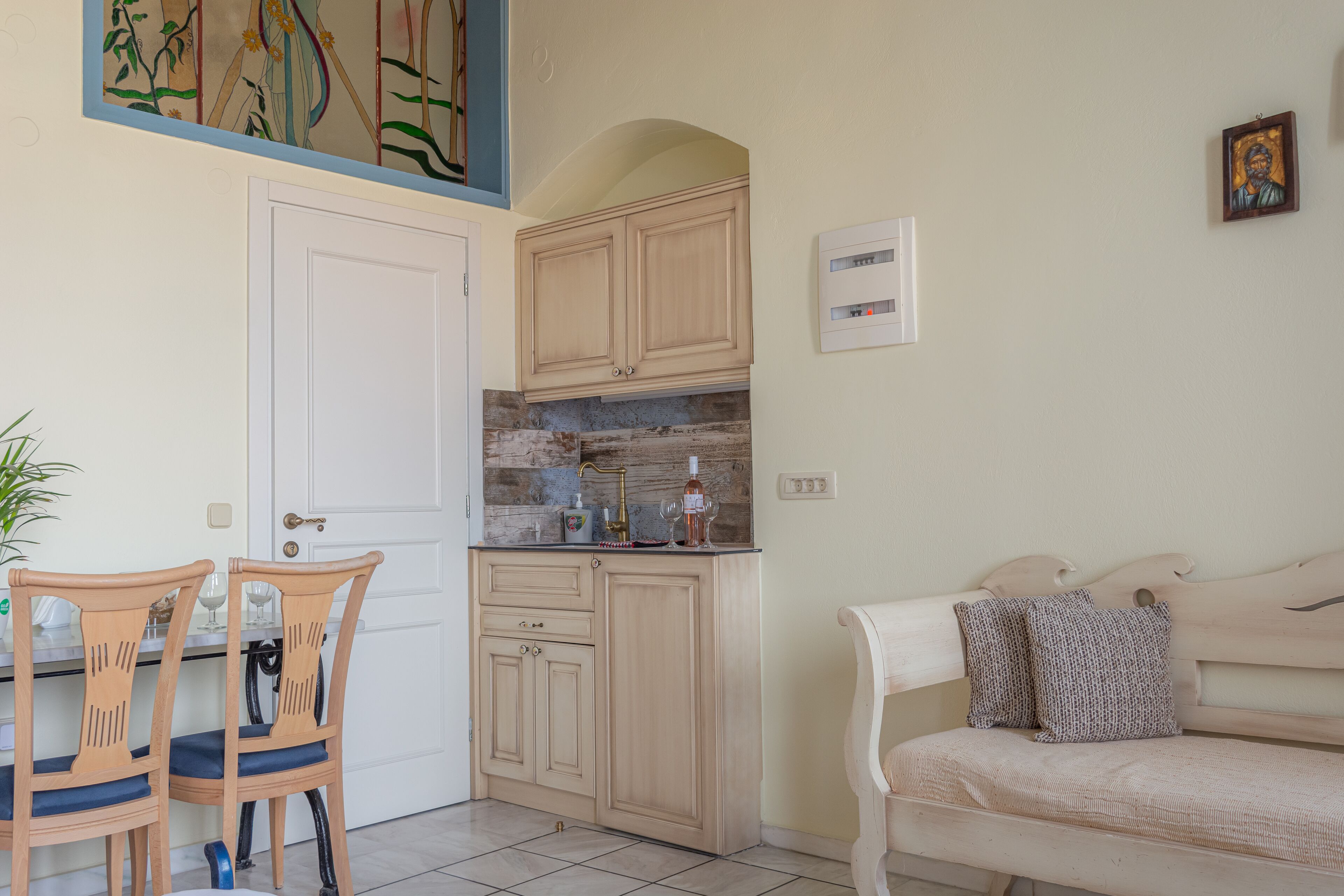 A kitchen with wooden cabinets, a dining table with chairs, and a sofa.