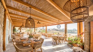 Un restaurante de planta abierta con muebles de madera y grandes ventanales que ofrecen vistas al paisaje.