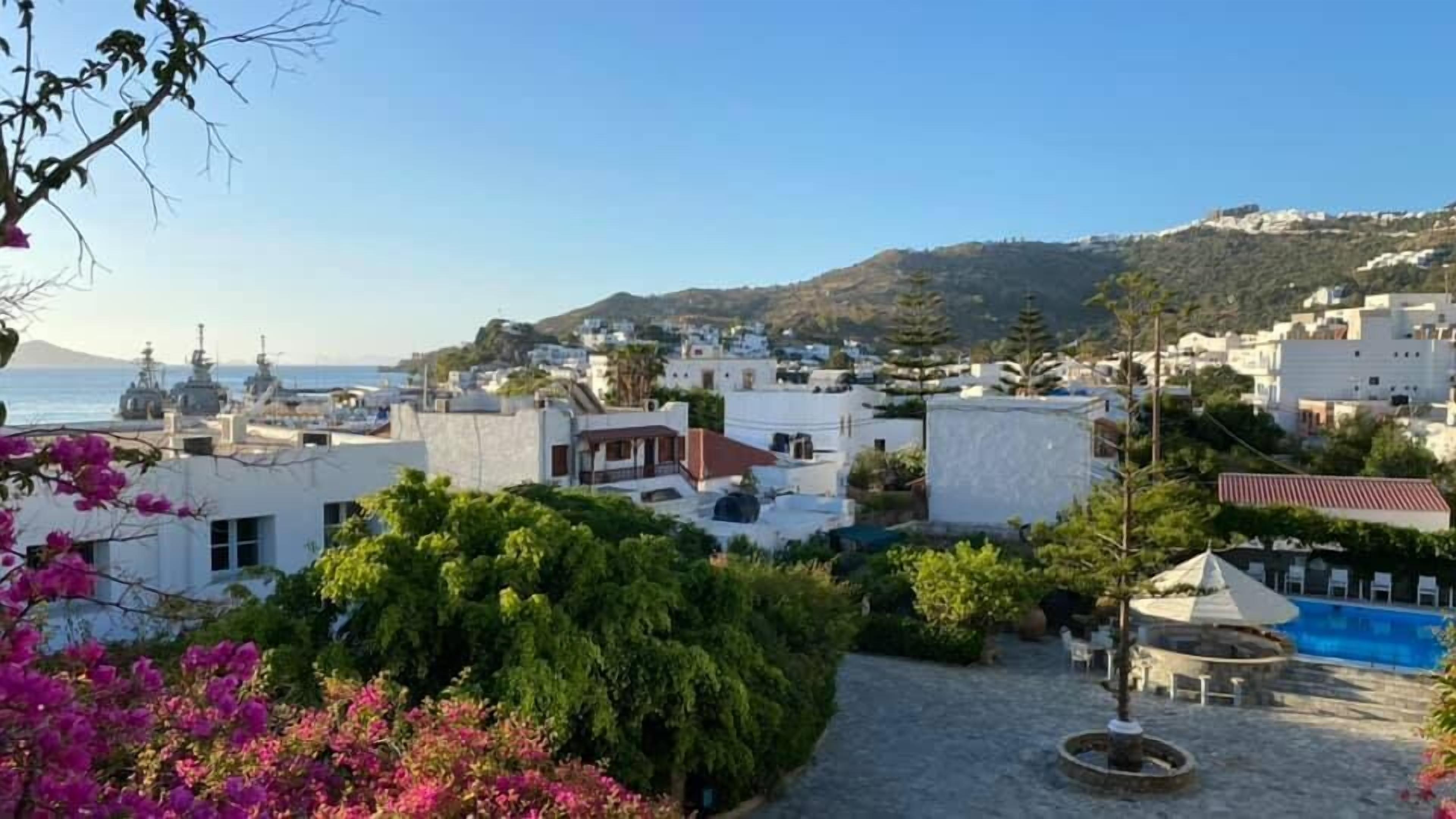 A coastal town with white buildings, a clear blue sky, and a view of the sea.