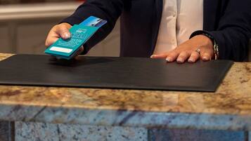 A person holding a hotel brochure at a reception desk.