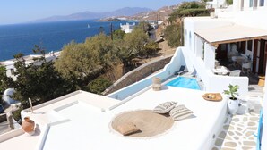 Una terraza en la azotea con piscina, arquitectura blanca y vistas al mar.