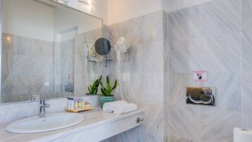 Een moderne badkamer met een grote spiegel, twee wastafels, een toilet en een douche.