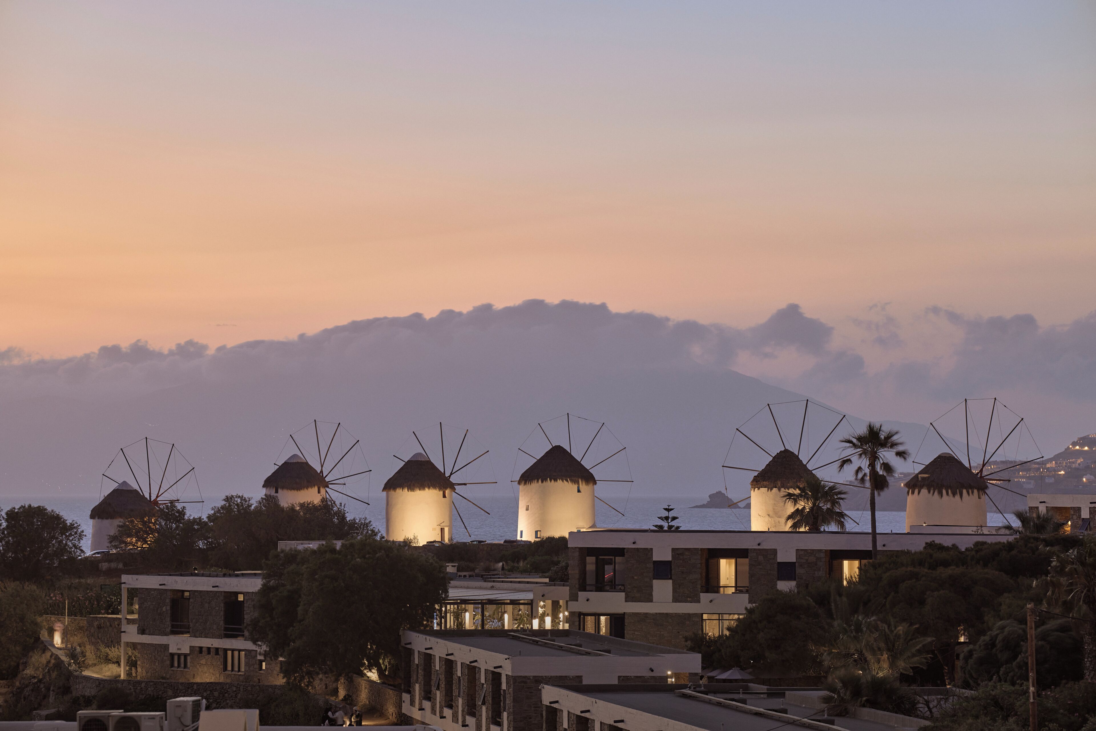 Un hotel costero con molinos, arquitectura moderna y vistas al mar.