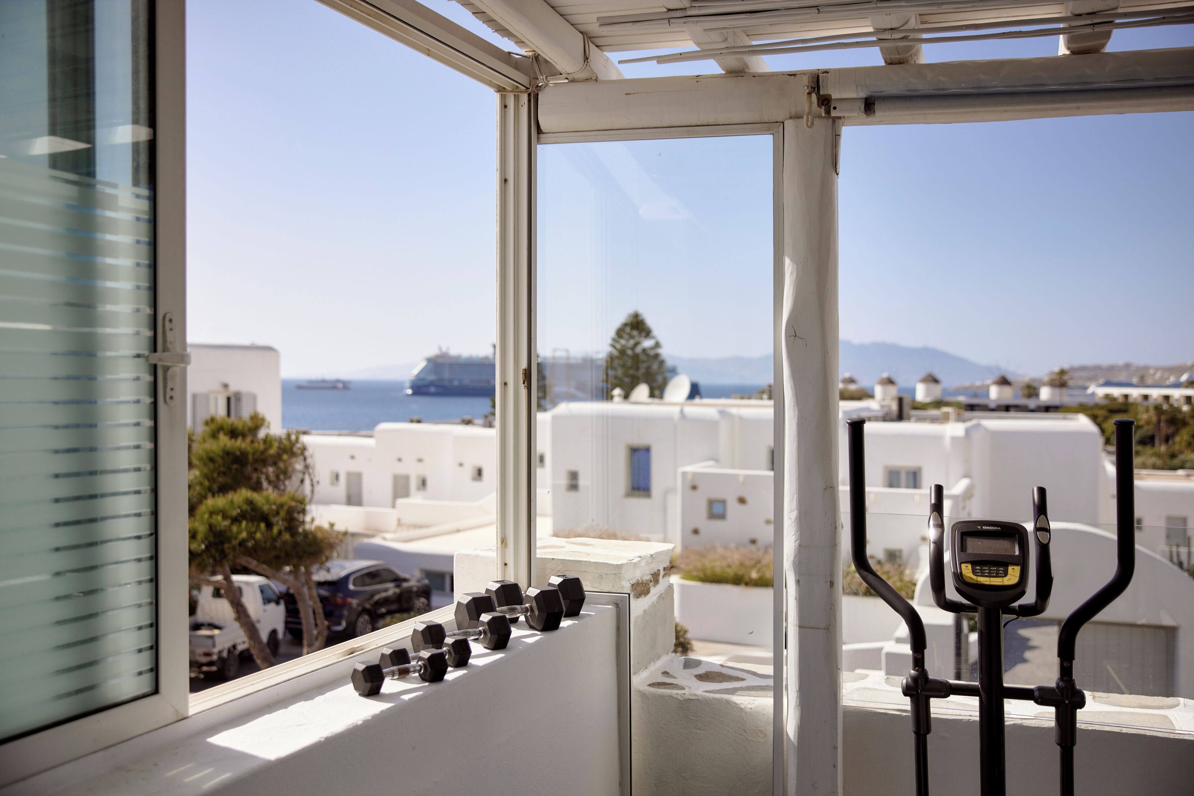 A window with a view of white buildings and a body of water.