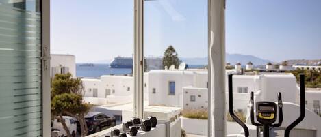A window with a view of white buildings and a body of water.