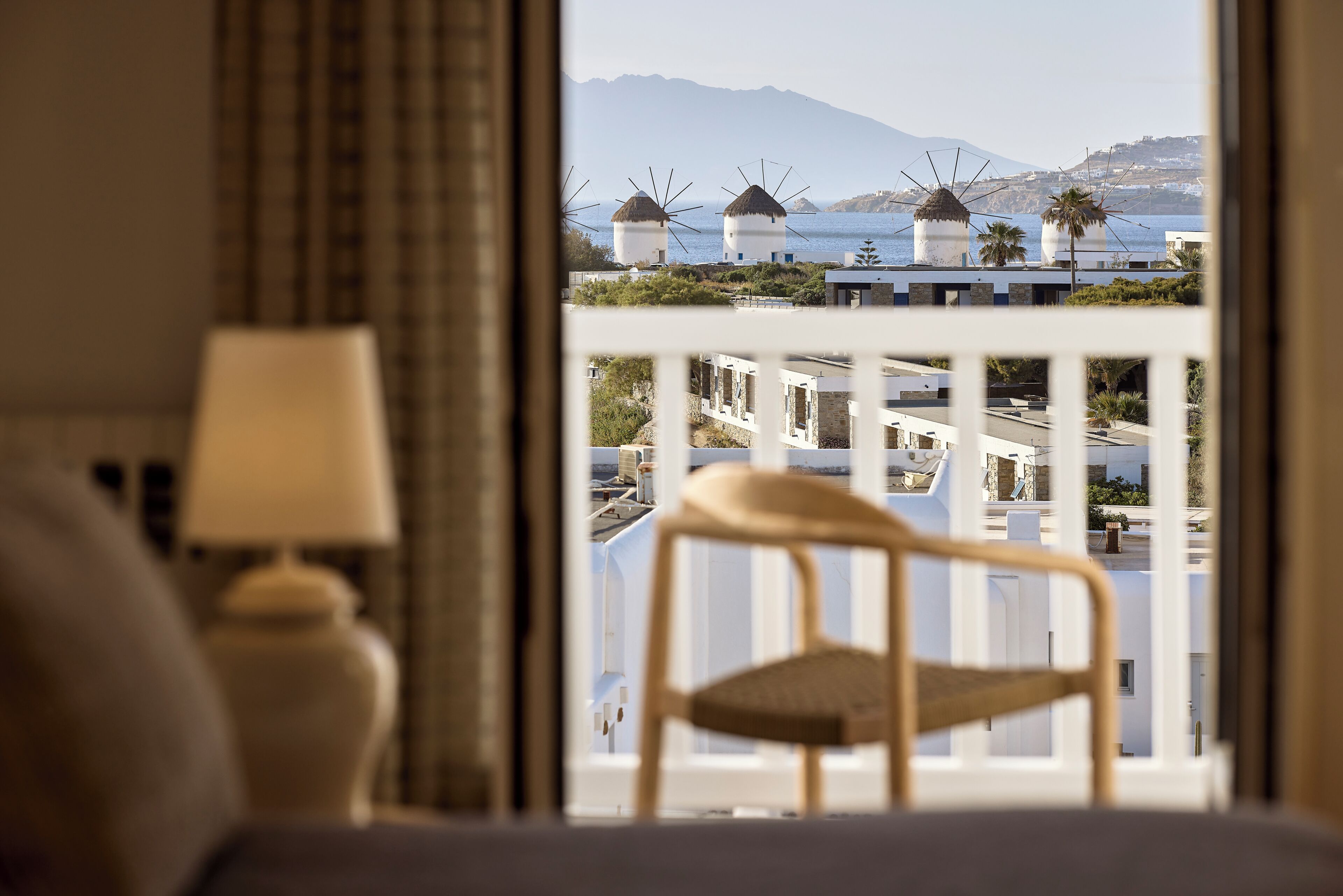 Una habitación con vistas a molinos, una silla y una lámpara.