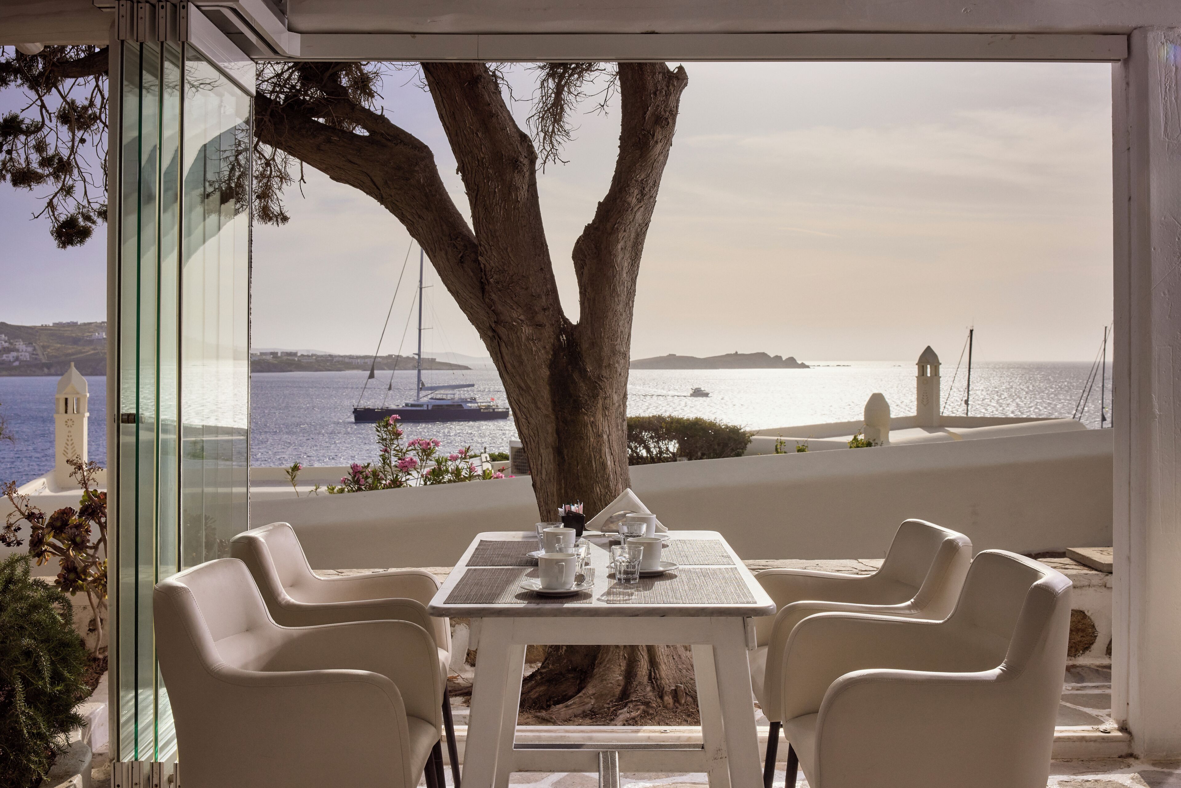 A table with chairs and a view of the sea.