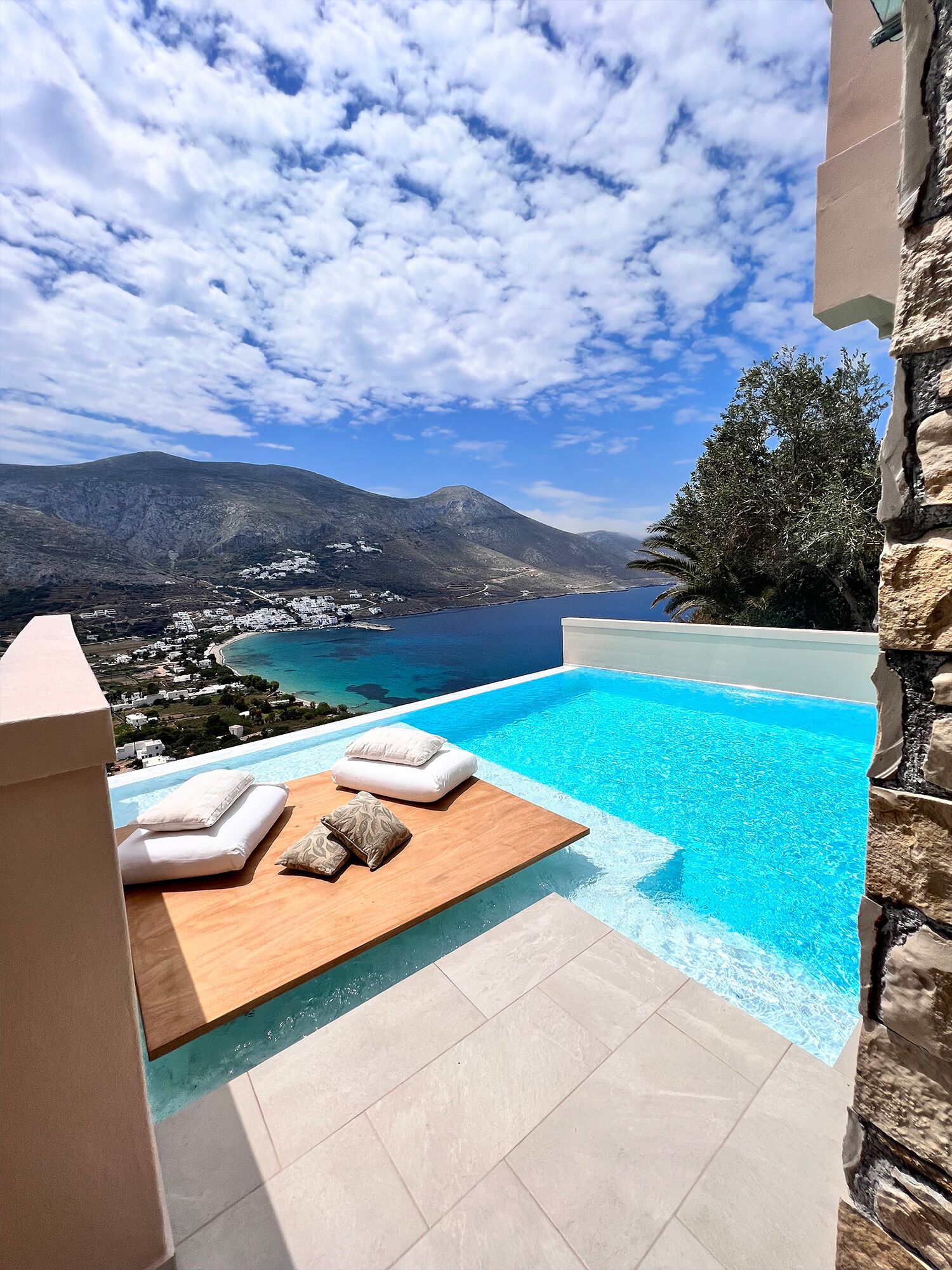 Una piscina infinita con vistas a un paisaje costero y montañas.