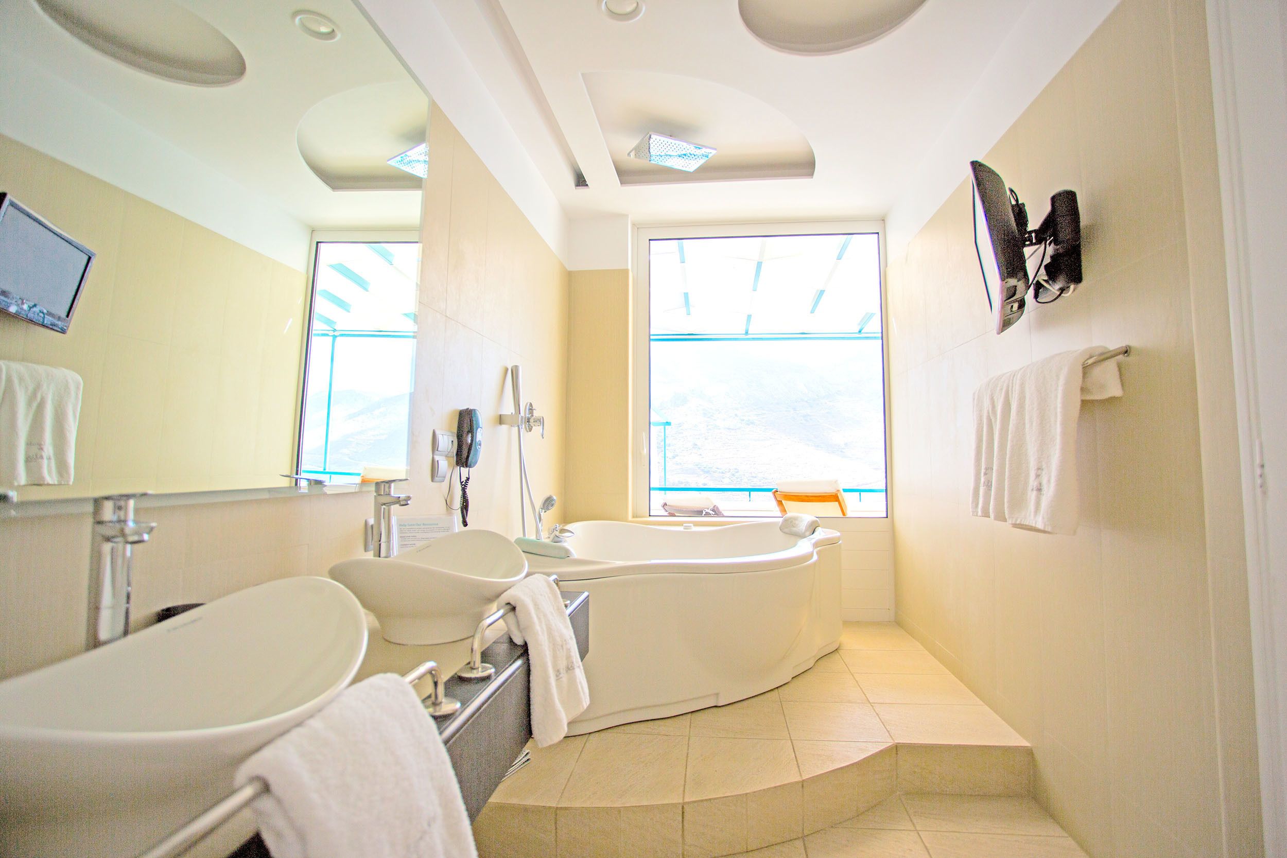 Un bagno moderno con una vasca freestanding, un lavandino ampio e uno specchio.