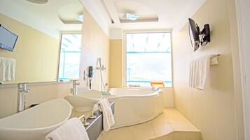 Un bagno moderno con una vasca freestanding, un lavandino ampio e uno specchio.