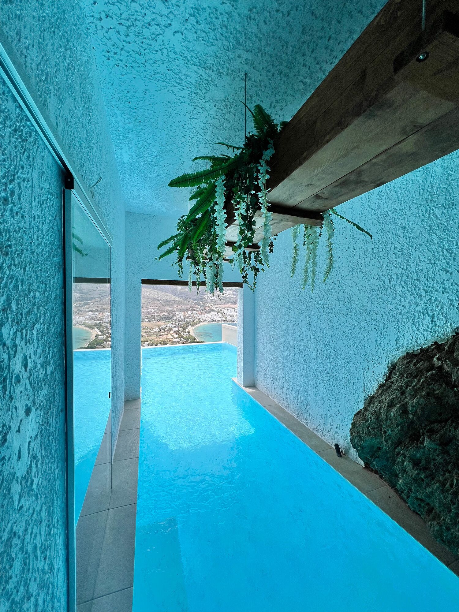 A modern infinity pool with a clear view of the coastline.