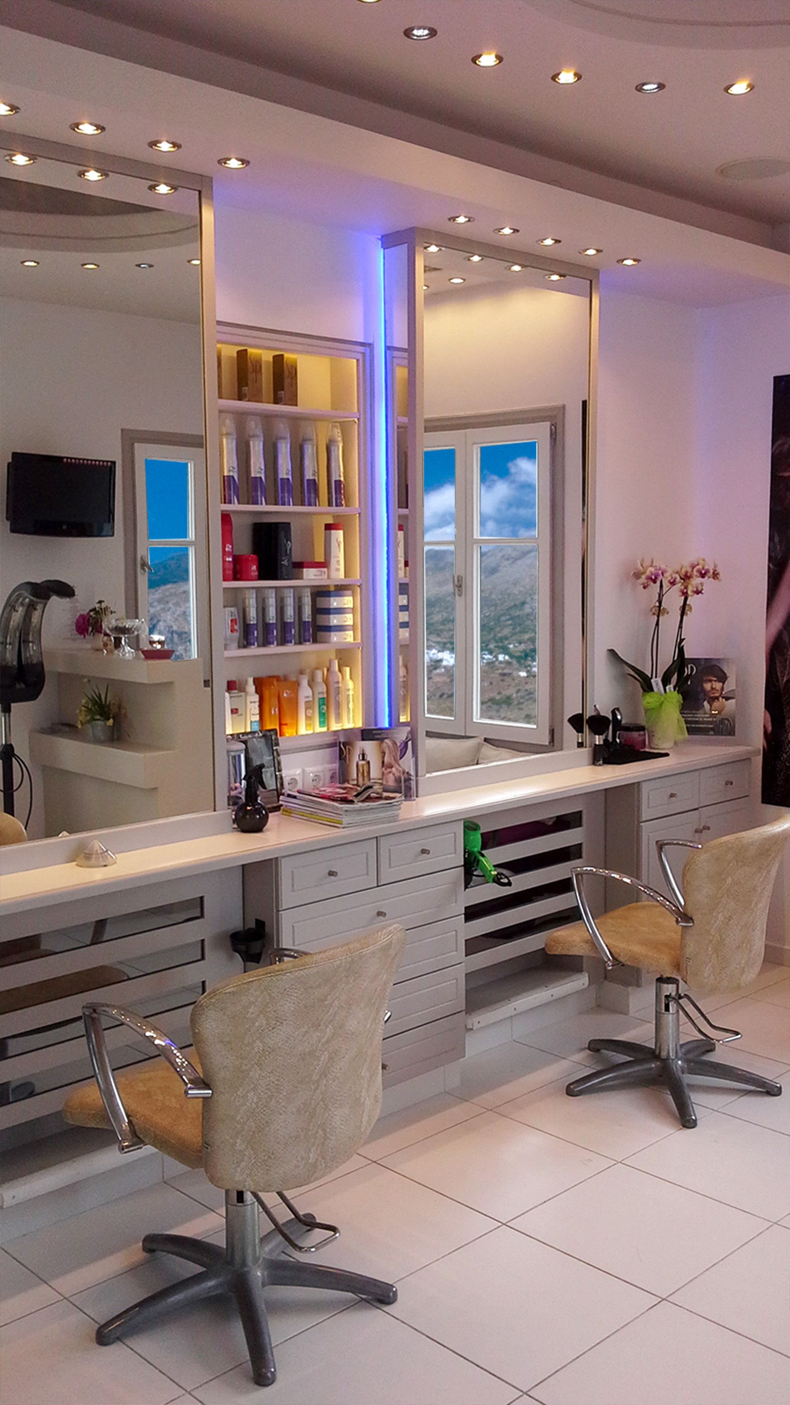 Een kapsalon met twee stoelen, een spiegel, planken met producten en een raam met uitzicht.