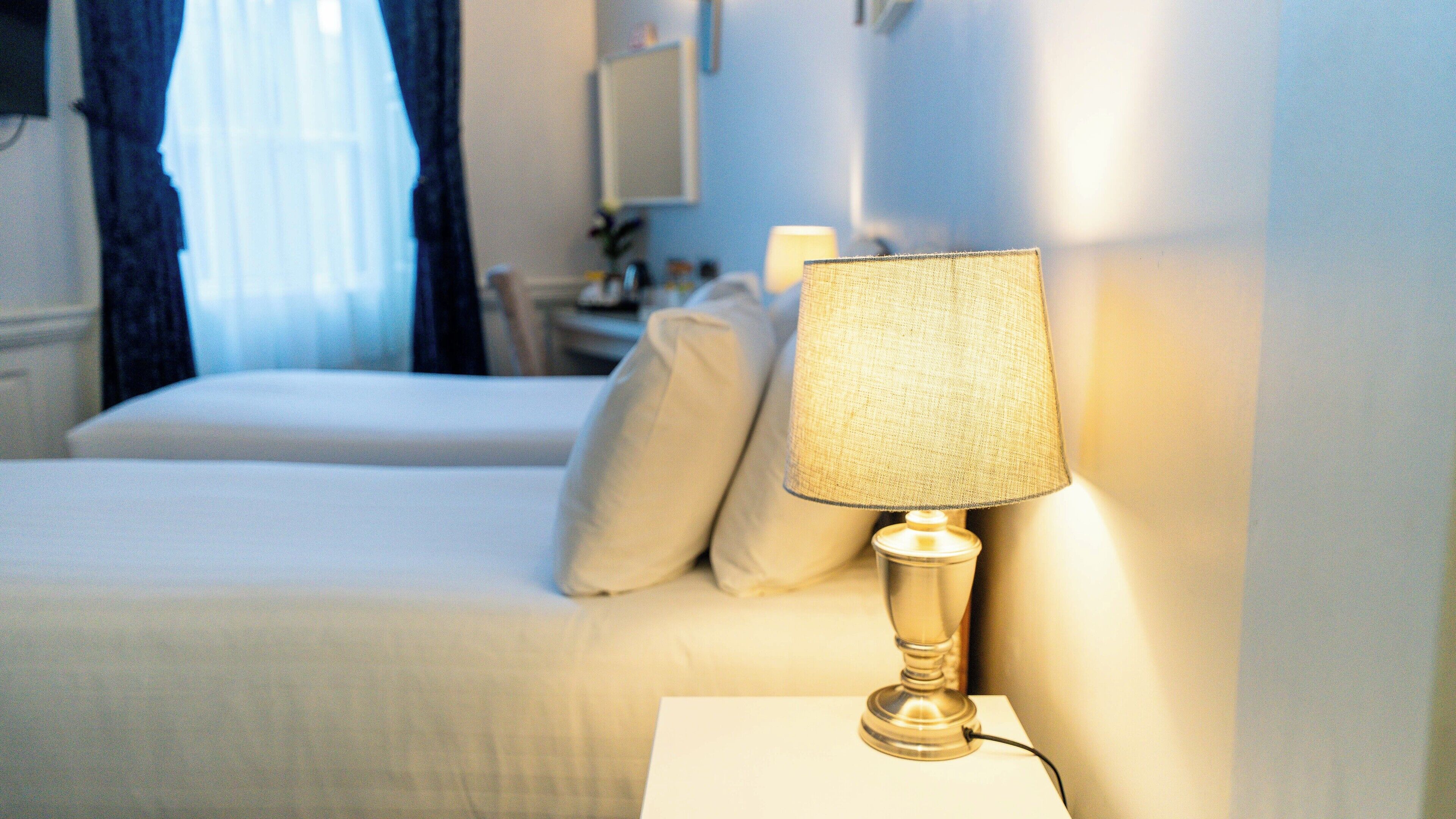 Une chambre d’hôtel avec un lit, une lampe de chevet et une table de nuit.