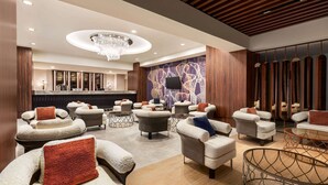 A modern lobby with plush seating, a central chandelier, and a reception desk. - Wyndham Bukhara (Bukhara)