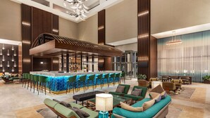 A spacious lobby with a bar area, seating arrangements, and a modern chandelier. - Wyndham Bukhara (Bukhara)