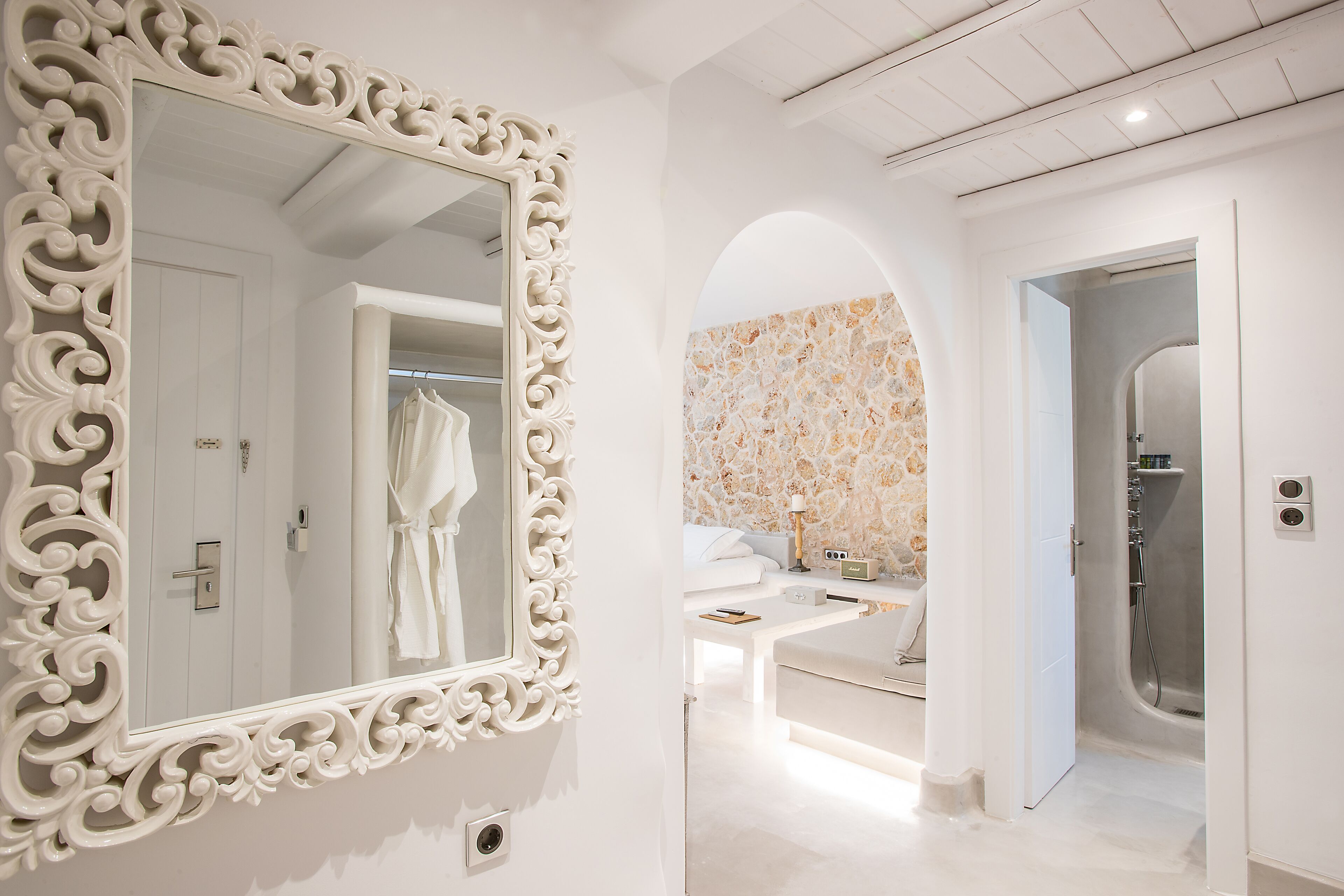Un bagno moderno con uno specchio grande e decorato, una doccia e un mobile lavabo con lavandino e piano di lavoro.