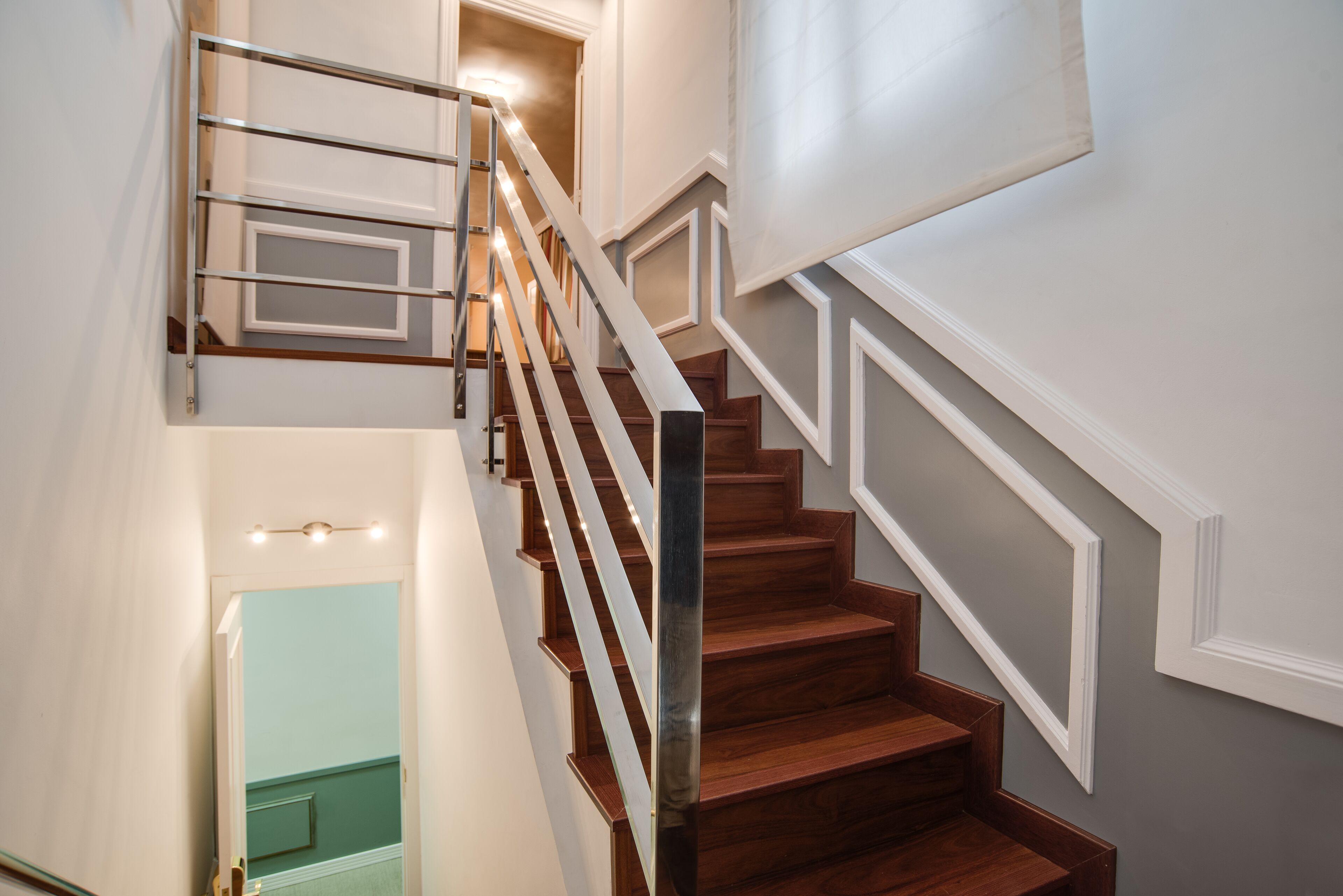 A staircase with wooden steps and metal railings, leading to an upper floor.