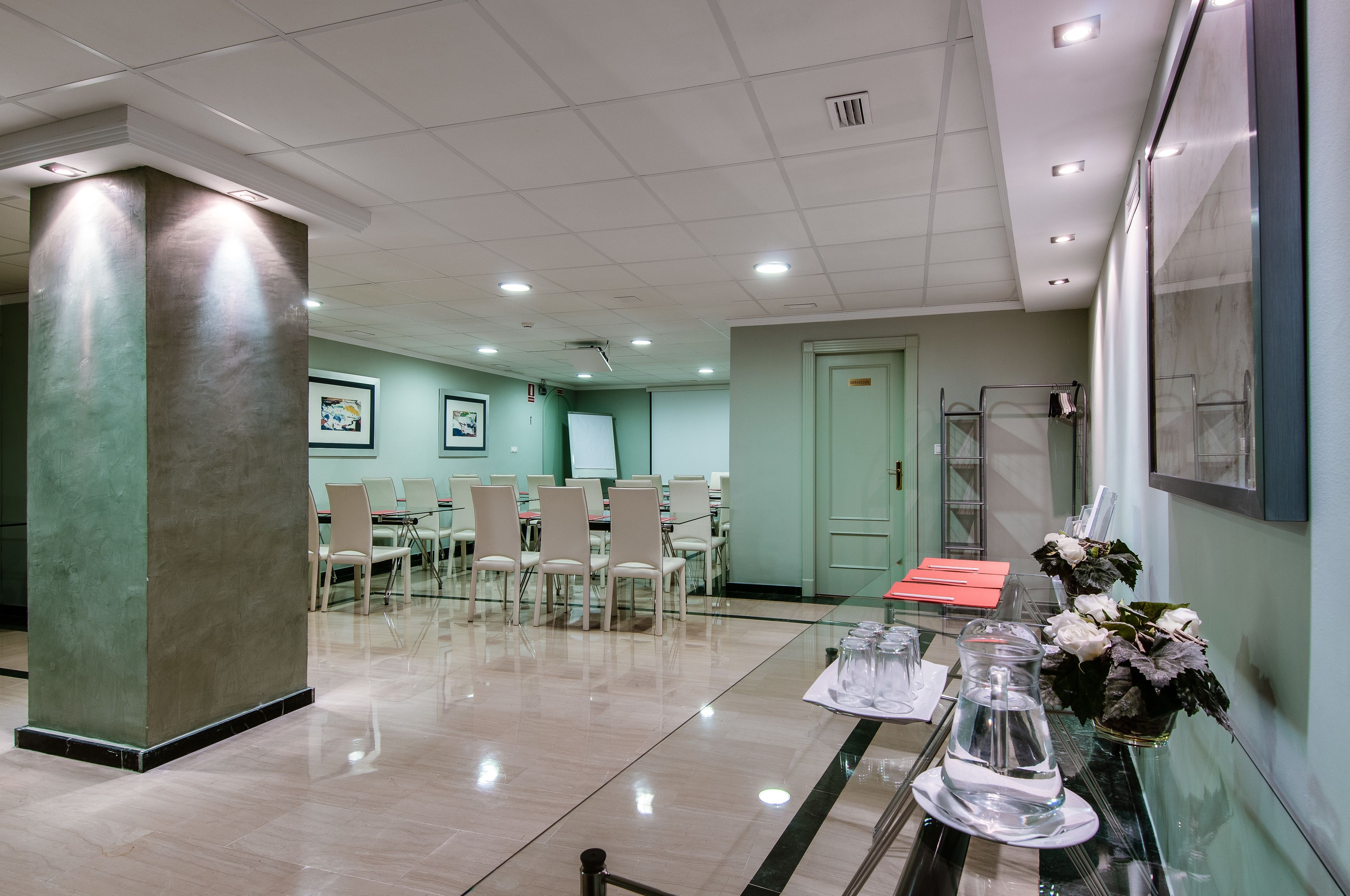 A hotel lobby with a conference room, a reception desk, and a glass partition.