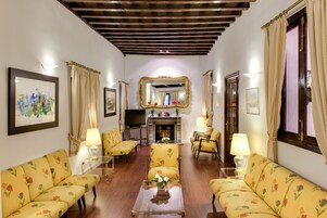 Un salón tradicional con sofás de estampado floral, una mesa de centro y una chimenea.