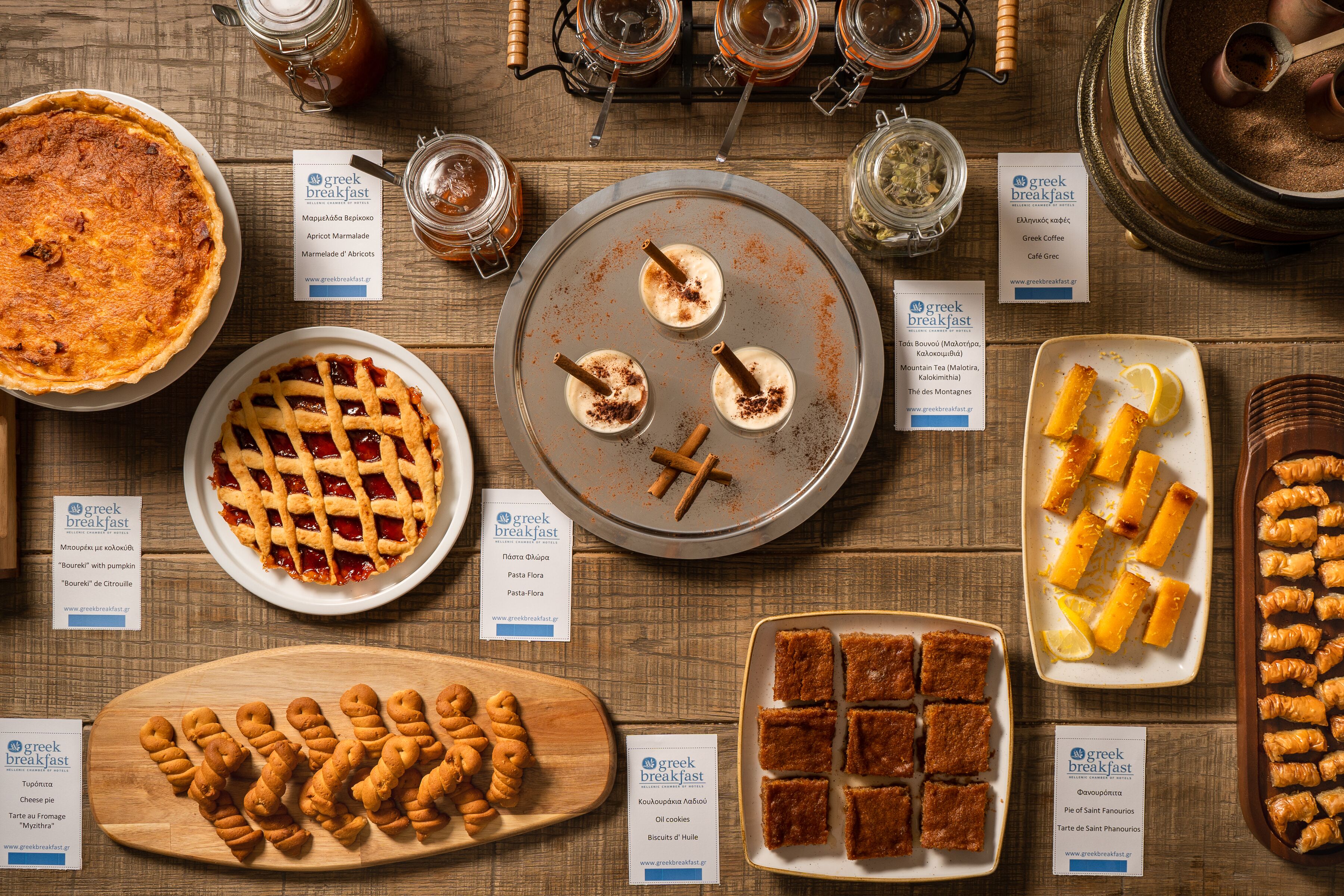 Variedad de platos típicos para el desayuno griego, incluyendo tartas, pasteles y postres.