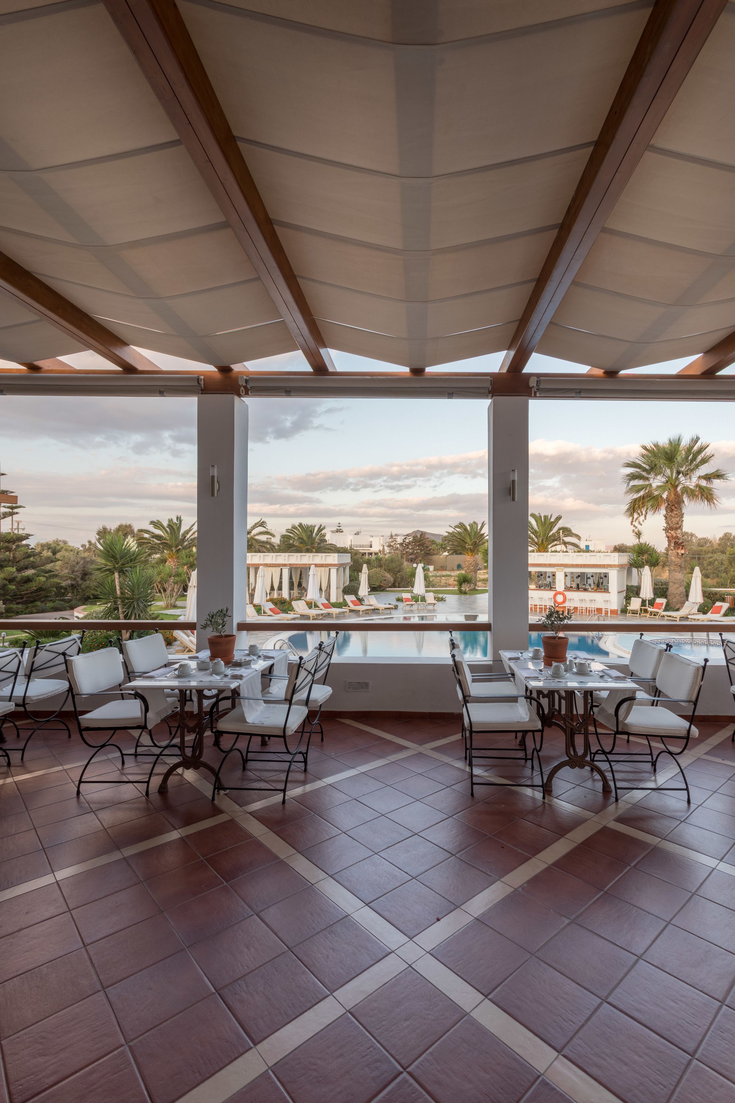 Frukost och lunch serveras, med utsikt mot poolen 